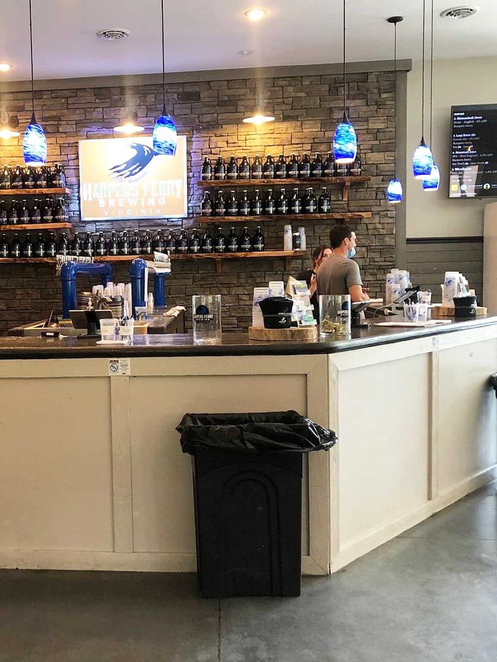 Craft brewery bar with craft beer taps, shelves of beer bottles, and casual seating at QuestForDirections.
