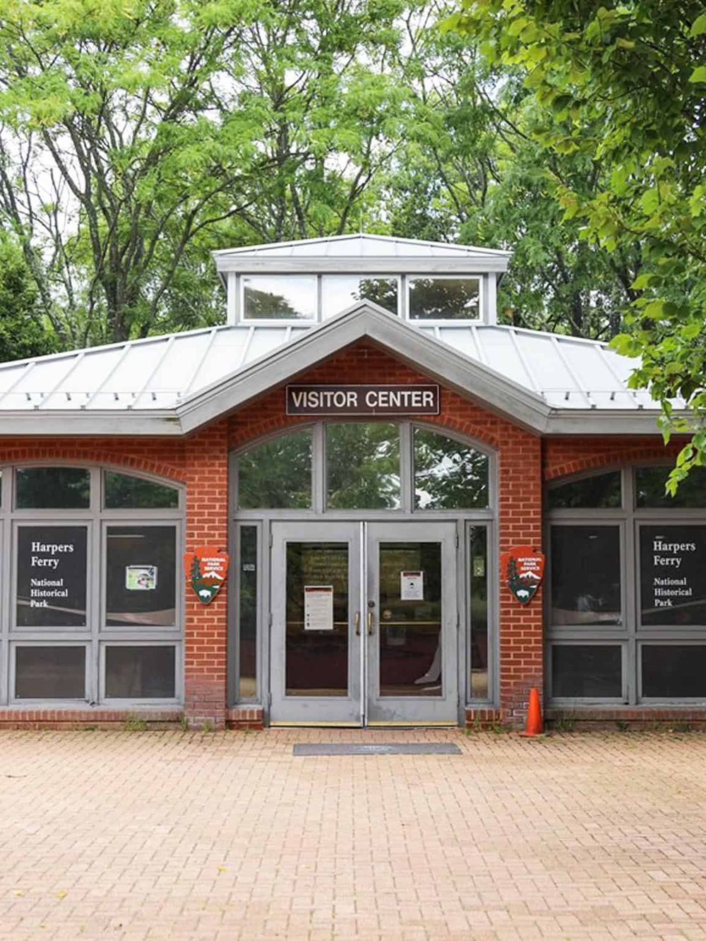 Historic visitor center building at Harpers Ferry National Historical Park, featuring brick walls and glass doors.