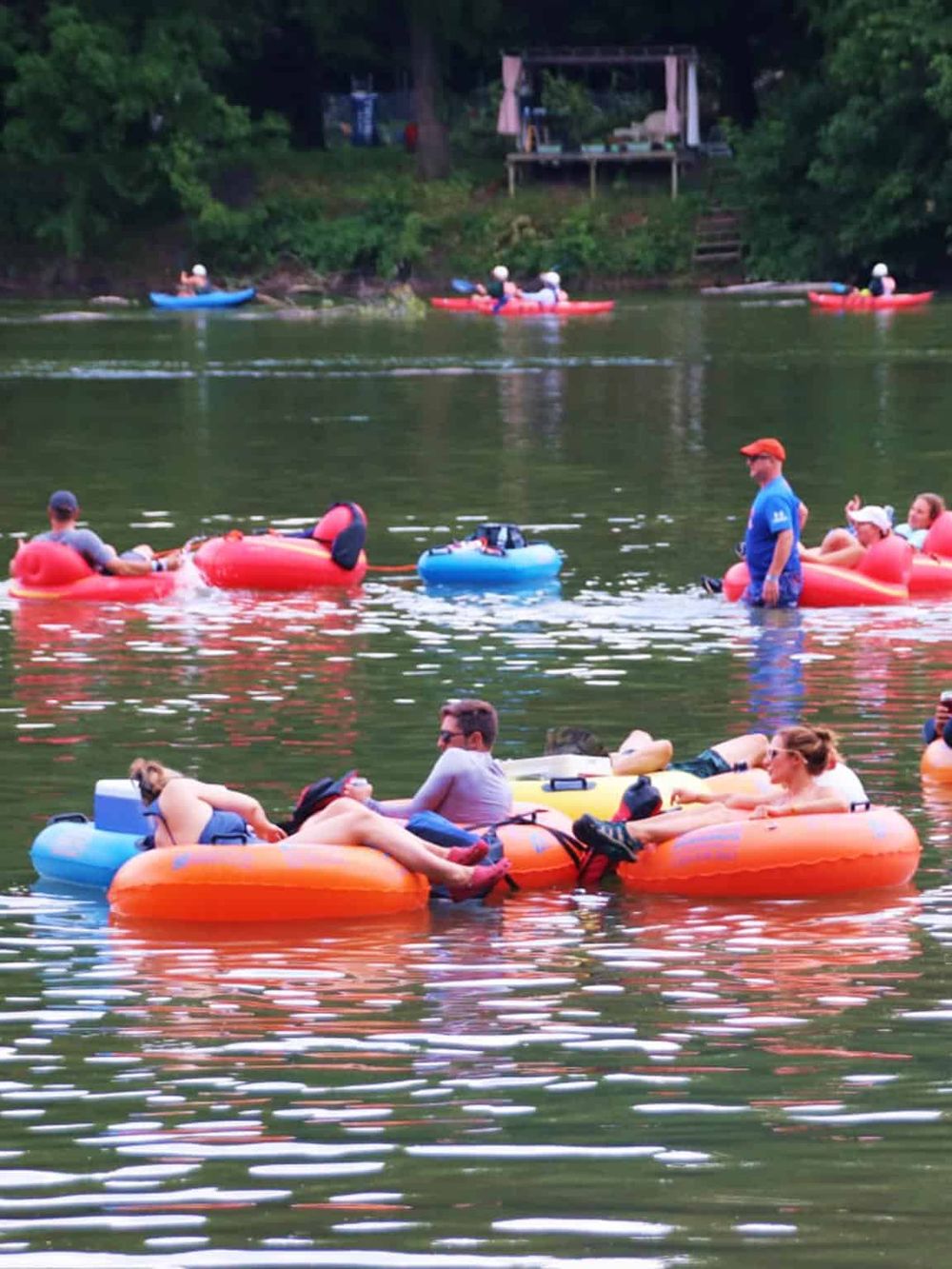 Floating on the water in inflatable tubes and kayaks during a summer outdoor adventure.