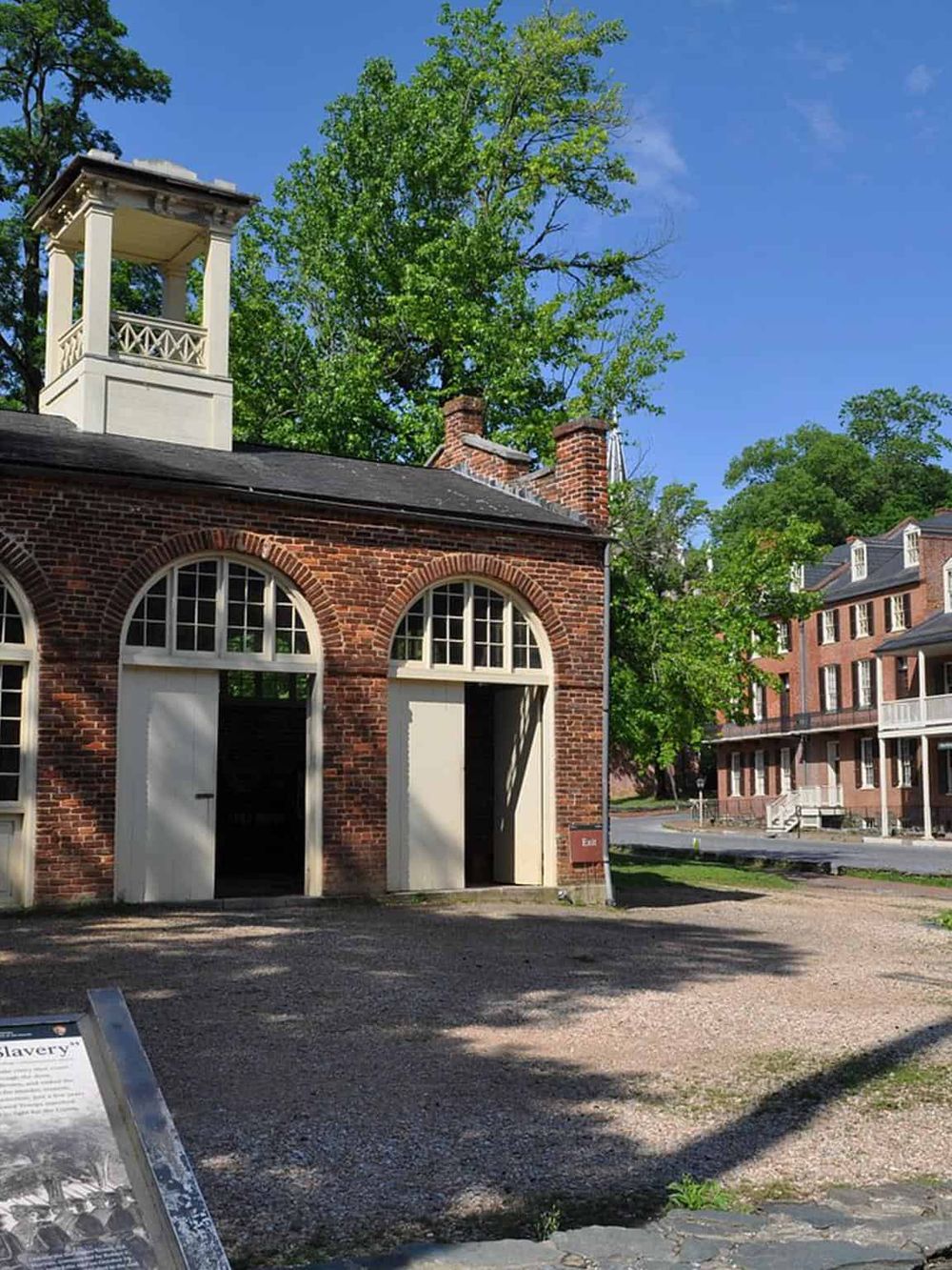 Old brick building with white accents and a small tower, historical site for American history.