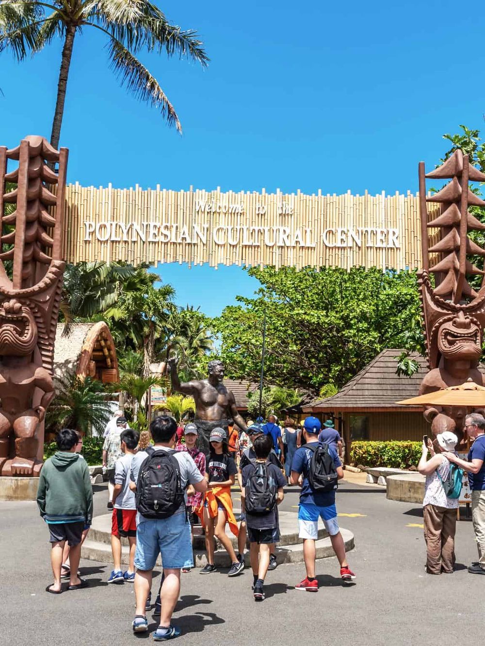People visiting Polynesian Cultural Center, a popular tourist attraction with Polynesian-themed exhibits.