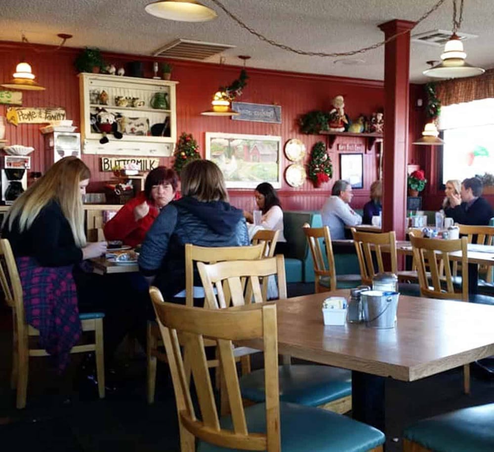 Cozy restaurant interior with holiday decorations and customers dining comfortably.