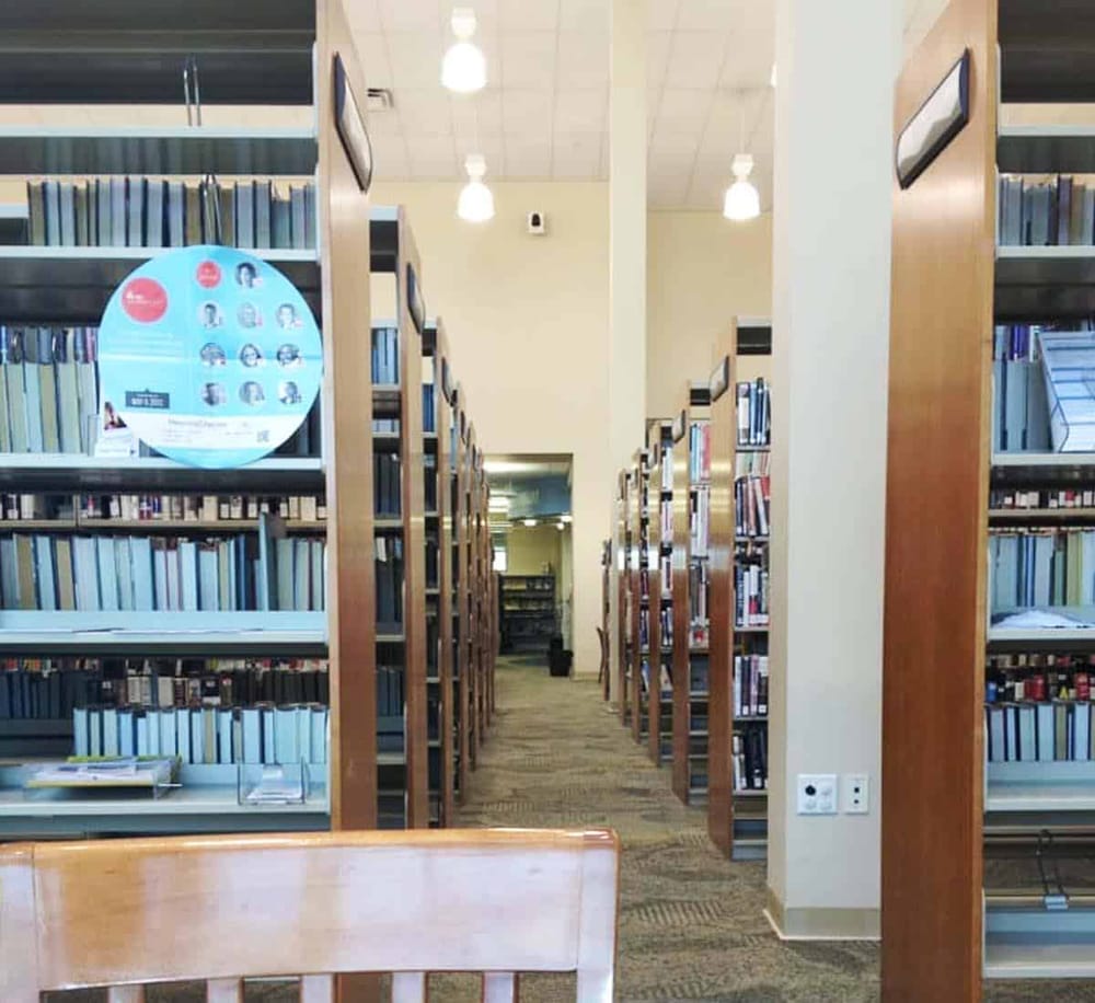 Accessible library shelves with organized books in a quiet study area.