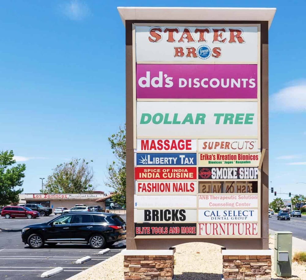 Colorful shopping plaza directory sign in a commercial parking lot.