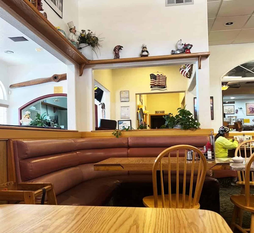 Cozy restaurant interior with wooden furniture and festive decorations, inviting atmosphere for dining and relaxation.