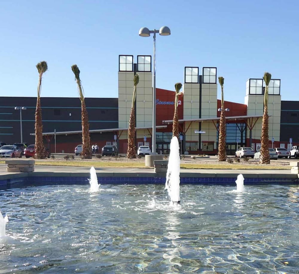 Modern shopping mall with water fountain and palm trees, popular destination for shopping and entertainment.