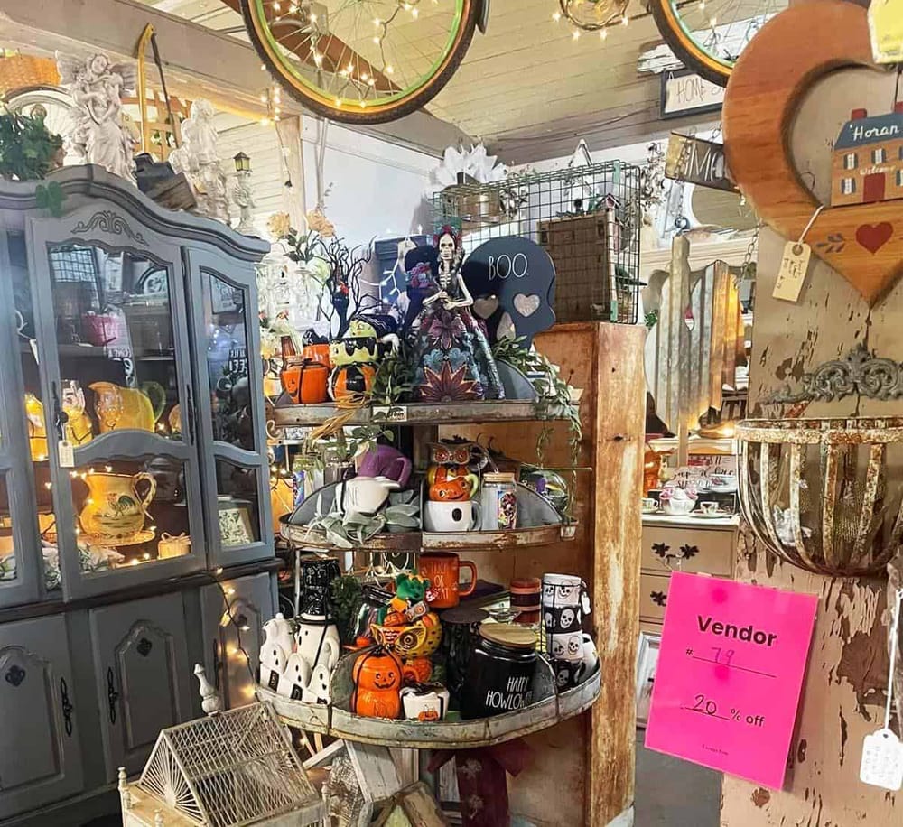 Halloween-themed gift shop display with pumpkins, skeleton figurines, and spooky decorations.
