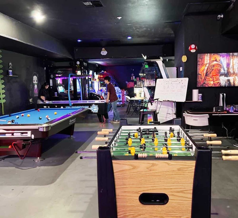 Arcade game room with pool tables, foosball, and gaming stations at QuestForDirections lounge.