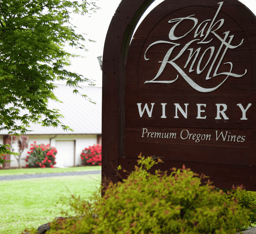 Rustic Oak Knoll Winery sign with greenery, showcasing Oregon wines and local vineyard destination.