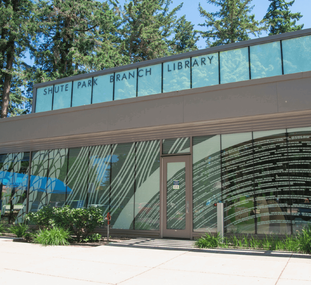 Quiet park branch library exterior with large glass windows and surrounding greenery.