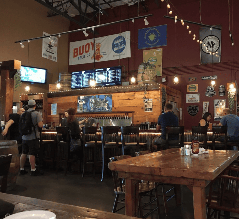 Bright brewery interior with bar and patrons enjoying craft beers and pub food at QuestForDirections.