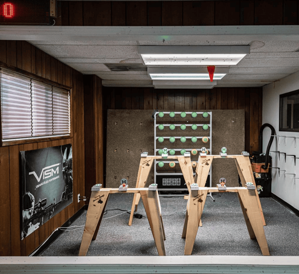 Indoor axe throwing game setup with wooden targets and safety gear. Perfect for team-building and recreational activities.