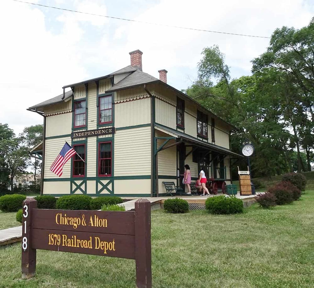 Vintage Railroad Depot Chicago & Alton 1879 historic train station with American flag, museum, and people visiting.