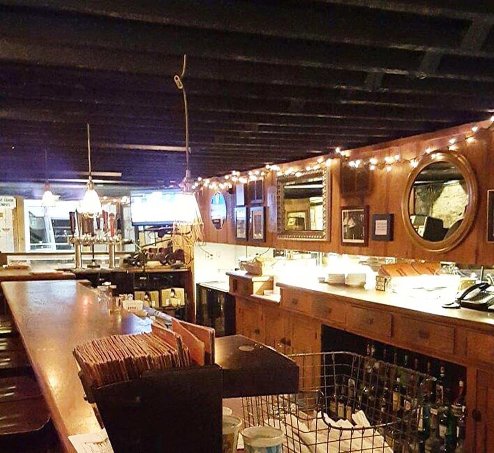 Cozy rustic bar interior with warm wood decor, string lights, and a casual atmosphere for dining and drinks.