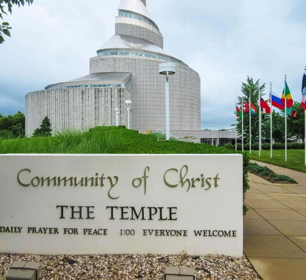 Modern church building at Community of Christ, with flags and well-maintained grounds.