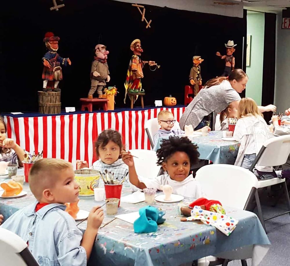 Colorful puppet show stage with children’s party activities and seating area for kids and families.