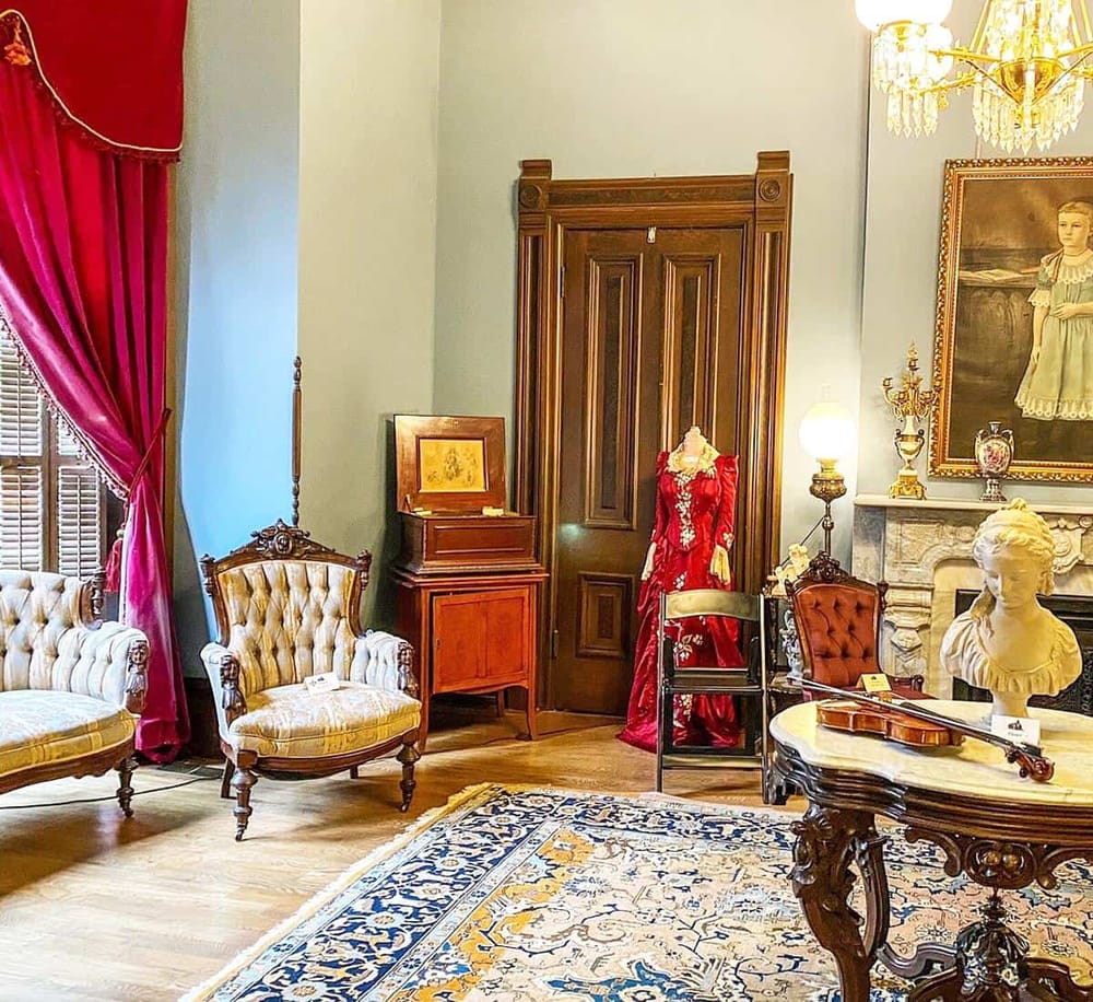 Antique Victorian furniture in elegant room with portrait and violin, classic decor, and vintage lighting.