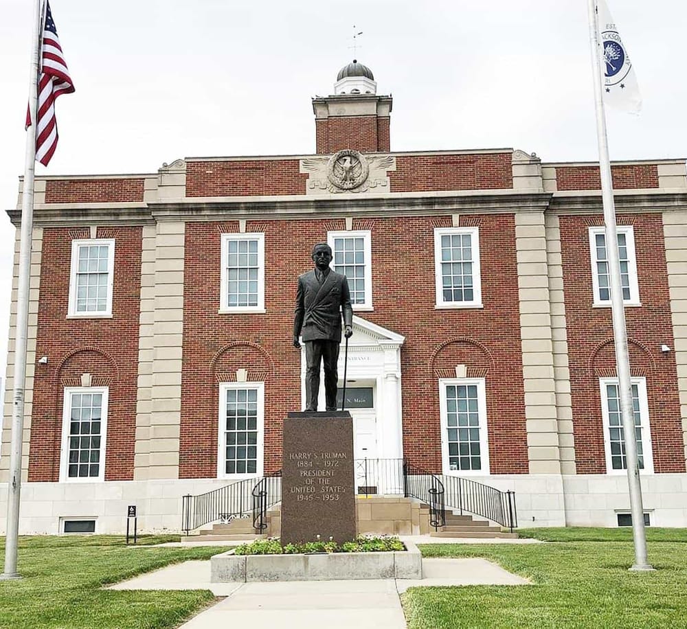 Historic courthouse with statue of Harry S. Truman in front, showcasing American history.