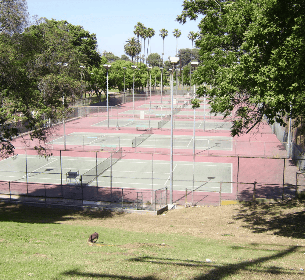Tennis courts in a lush, green park setting, perfect for sports and outdoor recreation.