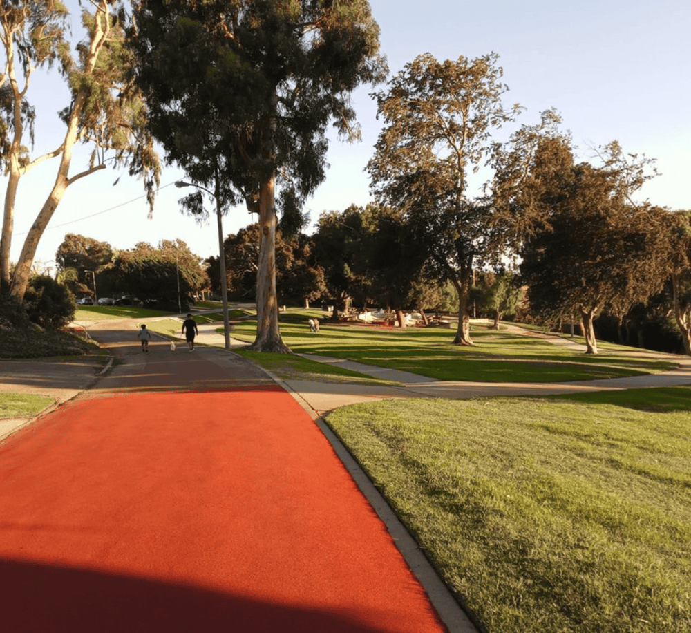 Colorful outdoor park with walking paths, large trees, and grassy areas for outdoor recreation.