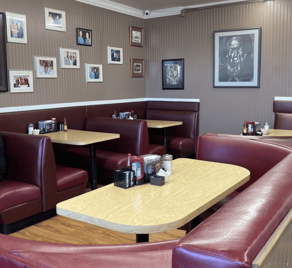 Cozy restaurant booth seating with framed art decor, perfect for casual dining.