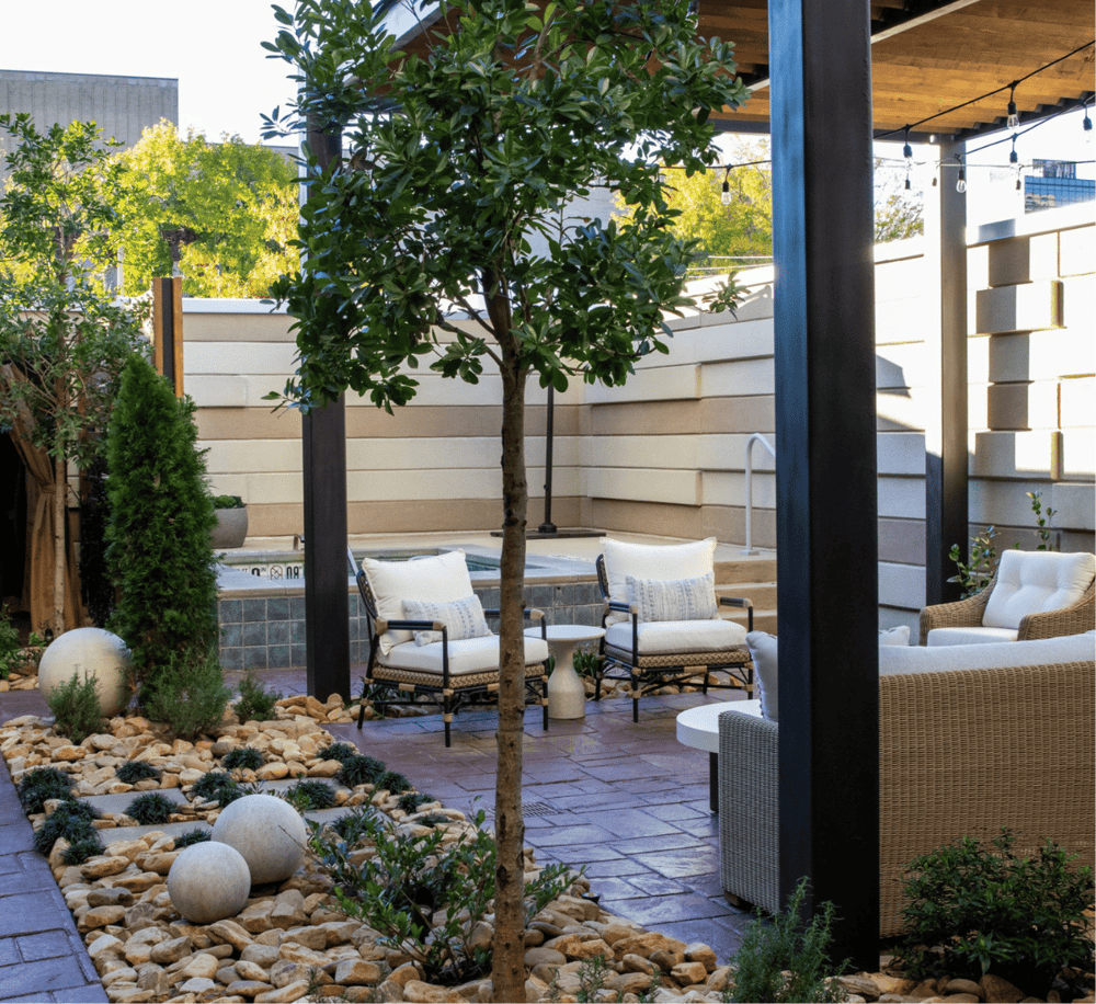 Modern outdoor patio garden with seating area, lush greenery, and stylish decor for relaxation.