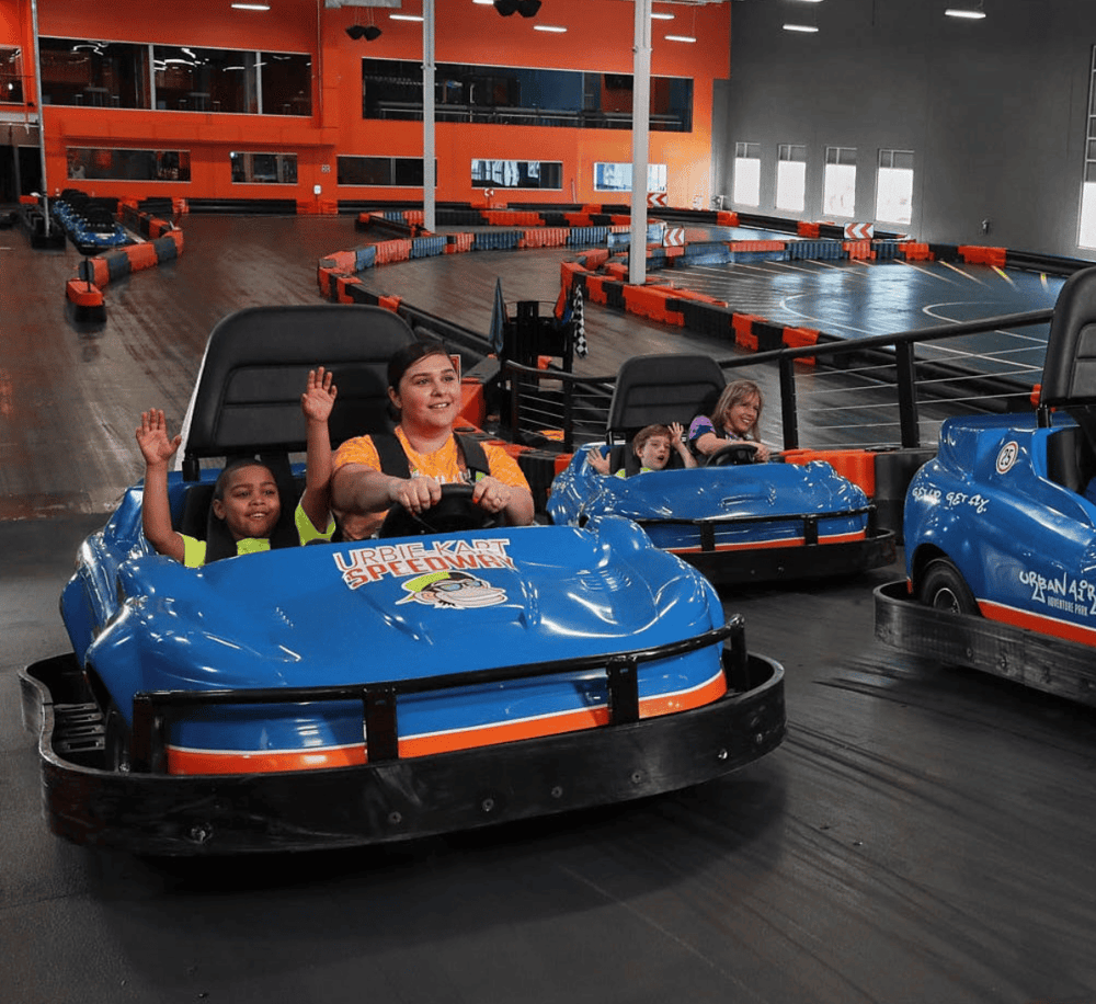 Kids enjoying go-kart racing experience at QuestForDirections indoor entertainment center.