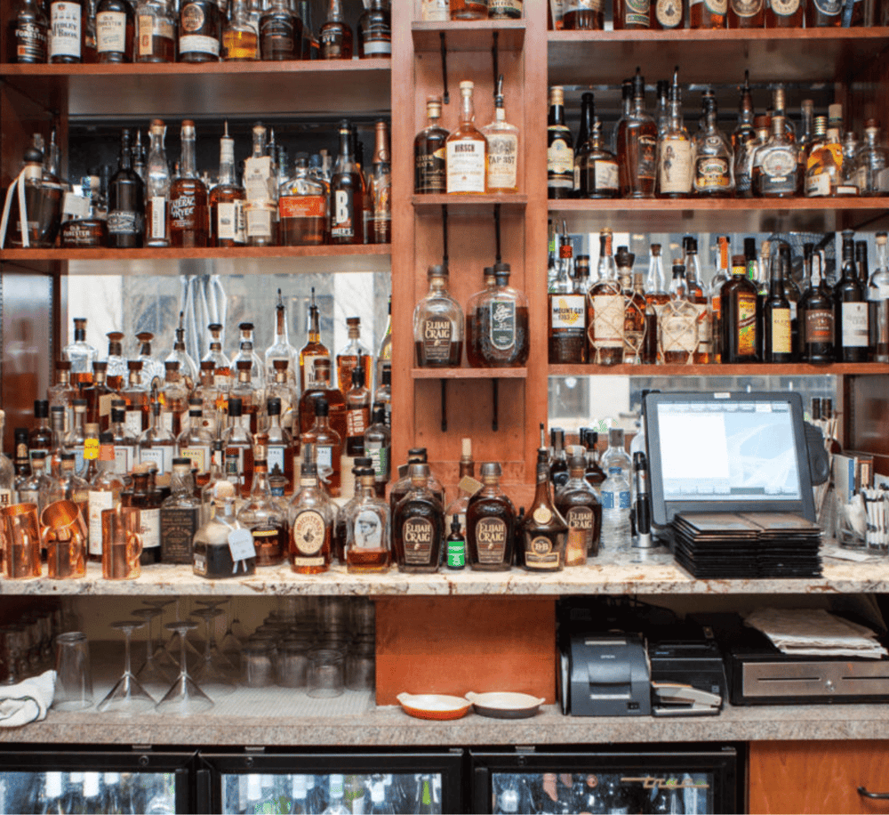 A wide selection of whiskey bottles on a bar shelf at QuestForDirections.