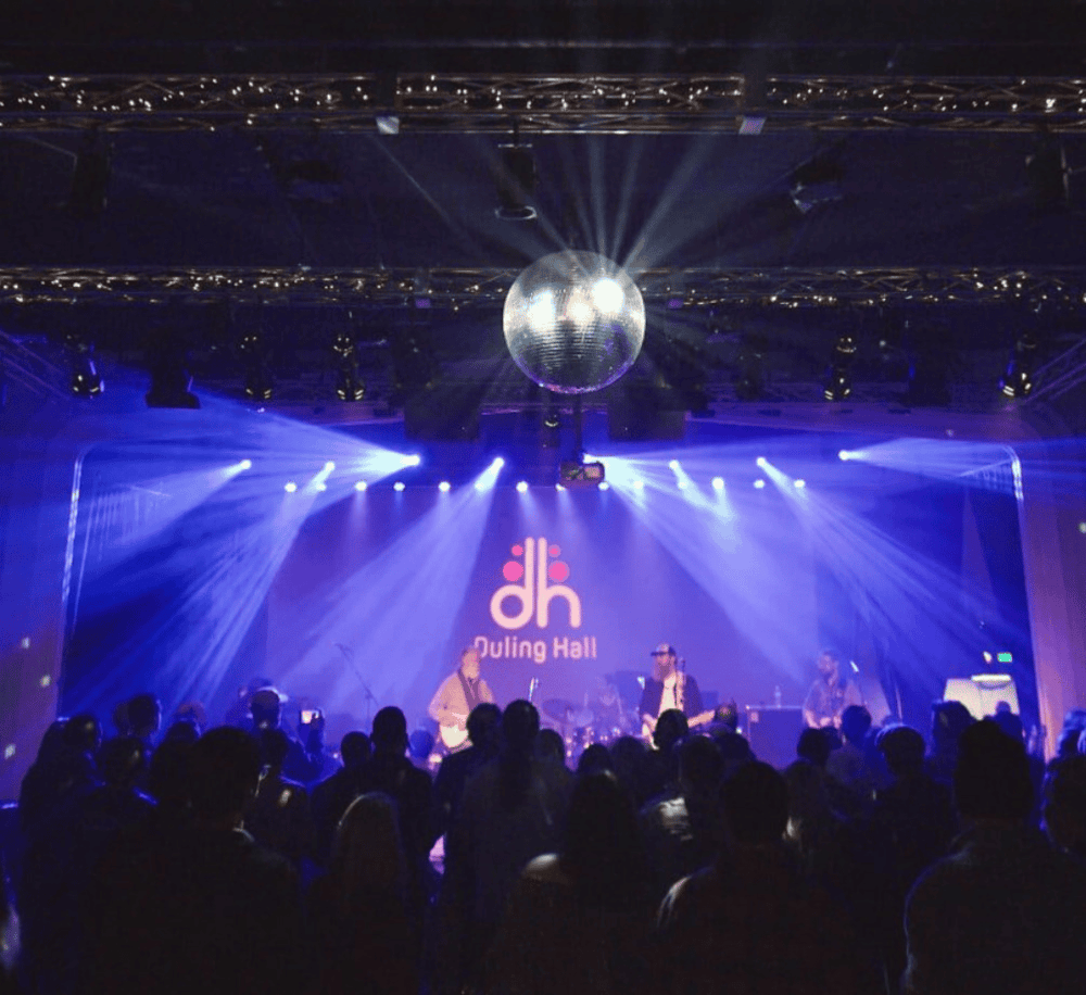 Vibrant live music performance at Douling Hall with stage lighting and a disco ball, ideal for events and concert venues.