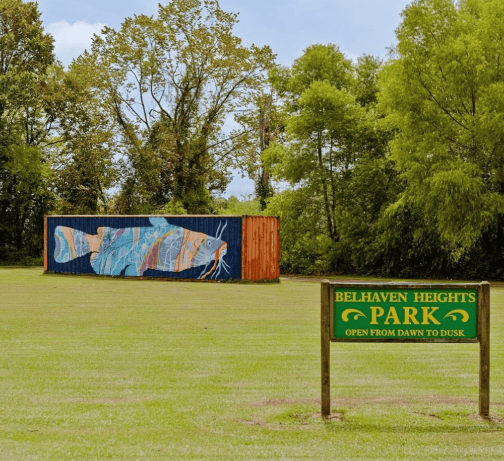 Colorful mural of a fish on a shipping container in Belhaven Heights Park, a scenic outdoor recreation area.