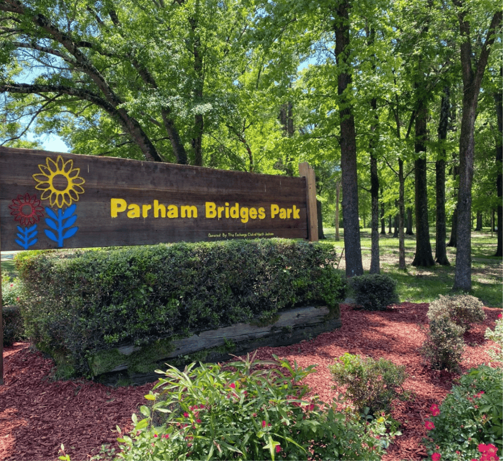 Tranquil park entrance at Parham Bridges Park, lush greenery, scenic nature, family-friendly outdoor space.