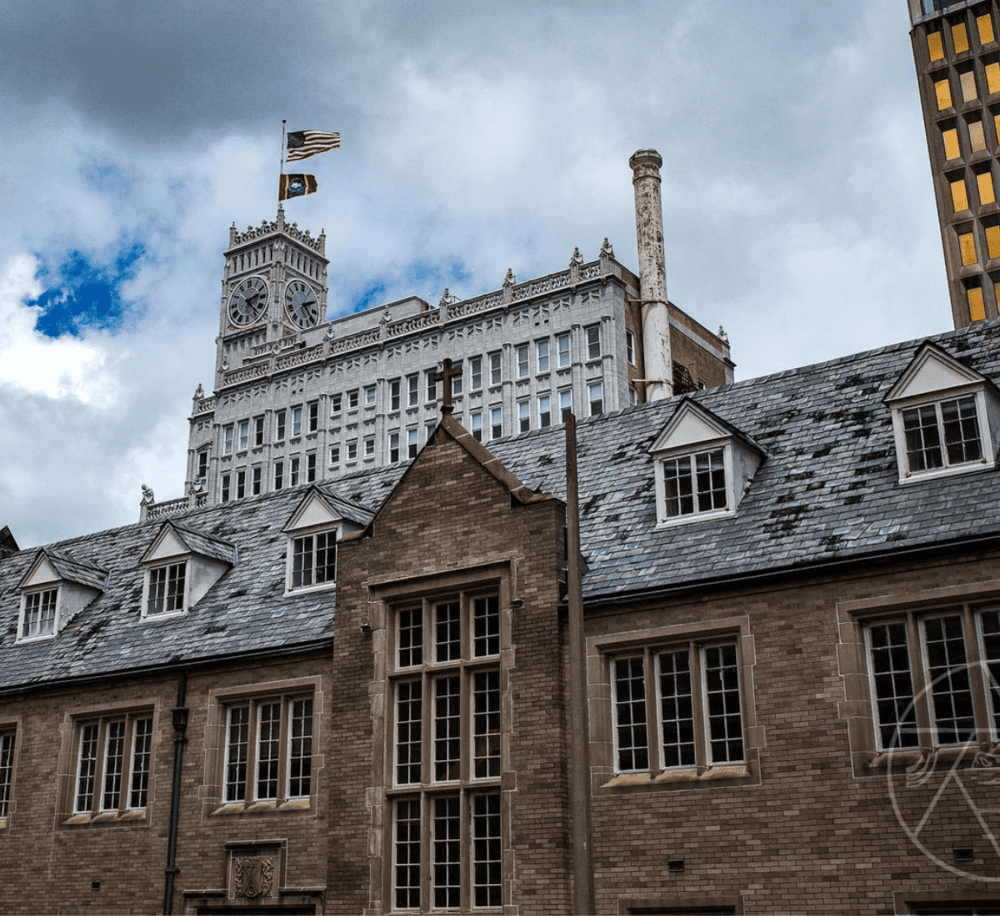 Historic city hall clock tower with modern skyscrapers in the background, representing urban architecture and cityscape.