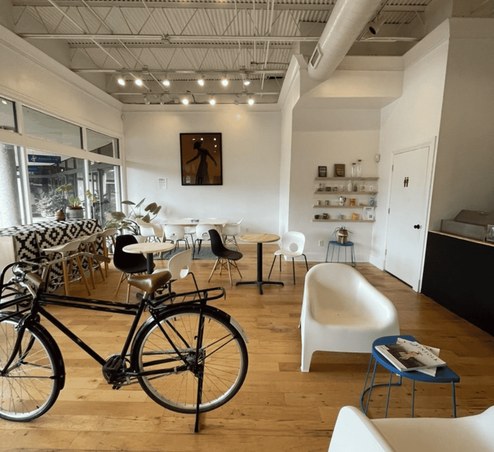 Cozy modern café interior with bicycles, stylish seating, and natural light for a welcoming experience.