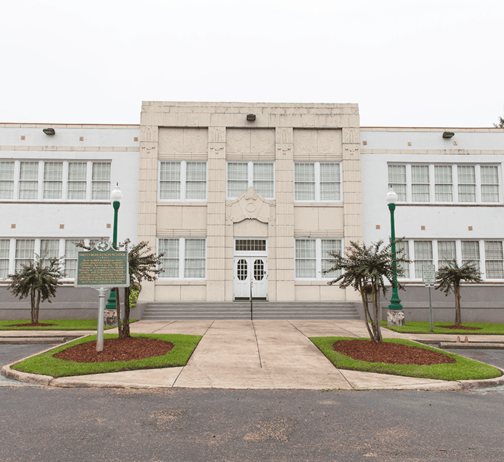 Historic city hall building with steps and trees, emphasizing local government and community services.