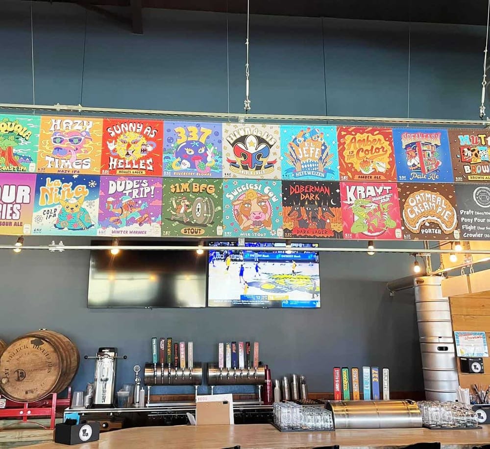 Colorful craft beer tap wall with beer labels at Quest for Directions brewery and bar.