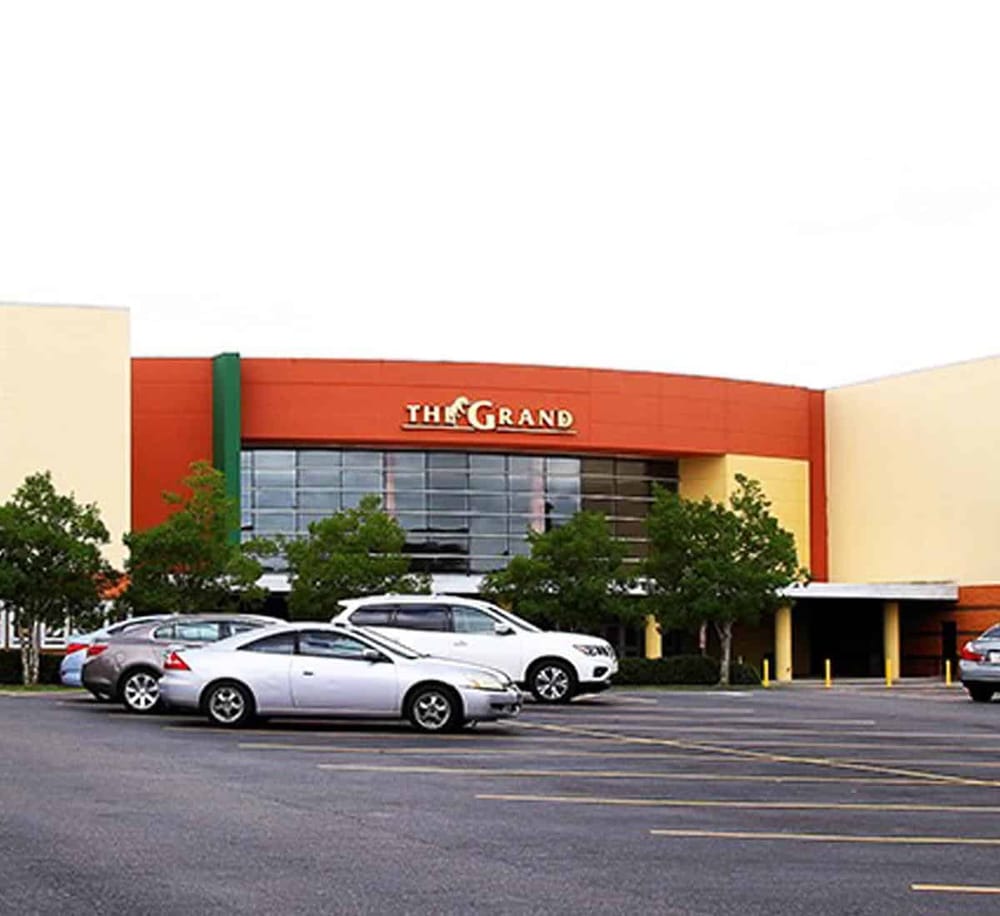 Modern shopping mall with parking area and greenery, part of QuestForDirections retail destinations.