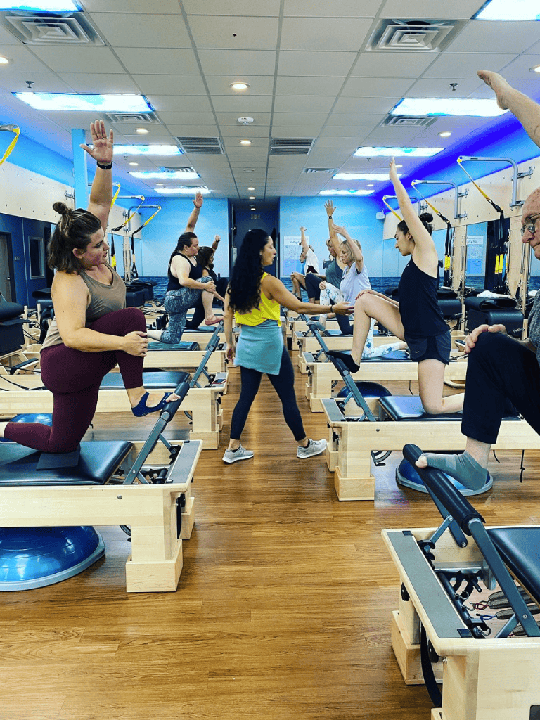 Gentle Pilates class at QuestForDirections studio with participants using reformer machines.