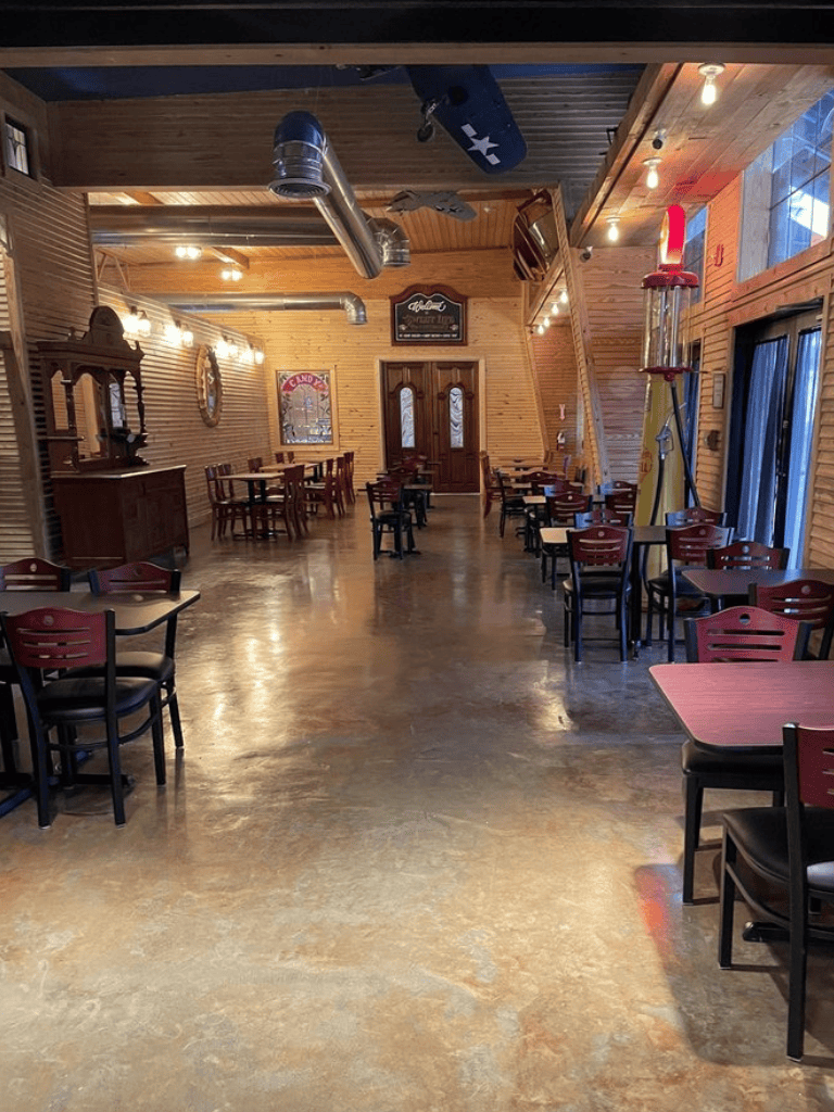 Indoor rustic restaurant with wooden walls and Dixon-style decor, featuring dim lighting and seating for diners.