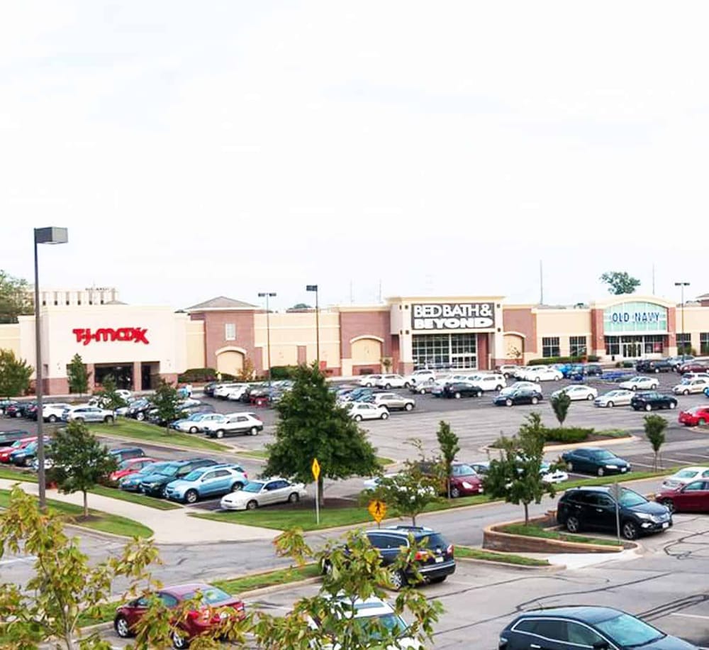 Bright shopping mall parking lot with popular stores and organized spaces, ideal for retail shopping and consumer visits.