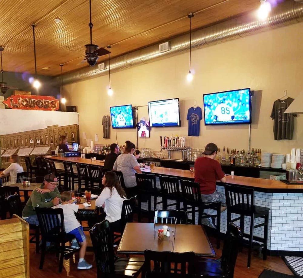 Cozy sports bar with multiple screens, bar seating, and casual dining atmosphere, ideal for watching games and socializing.