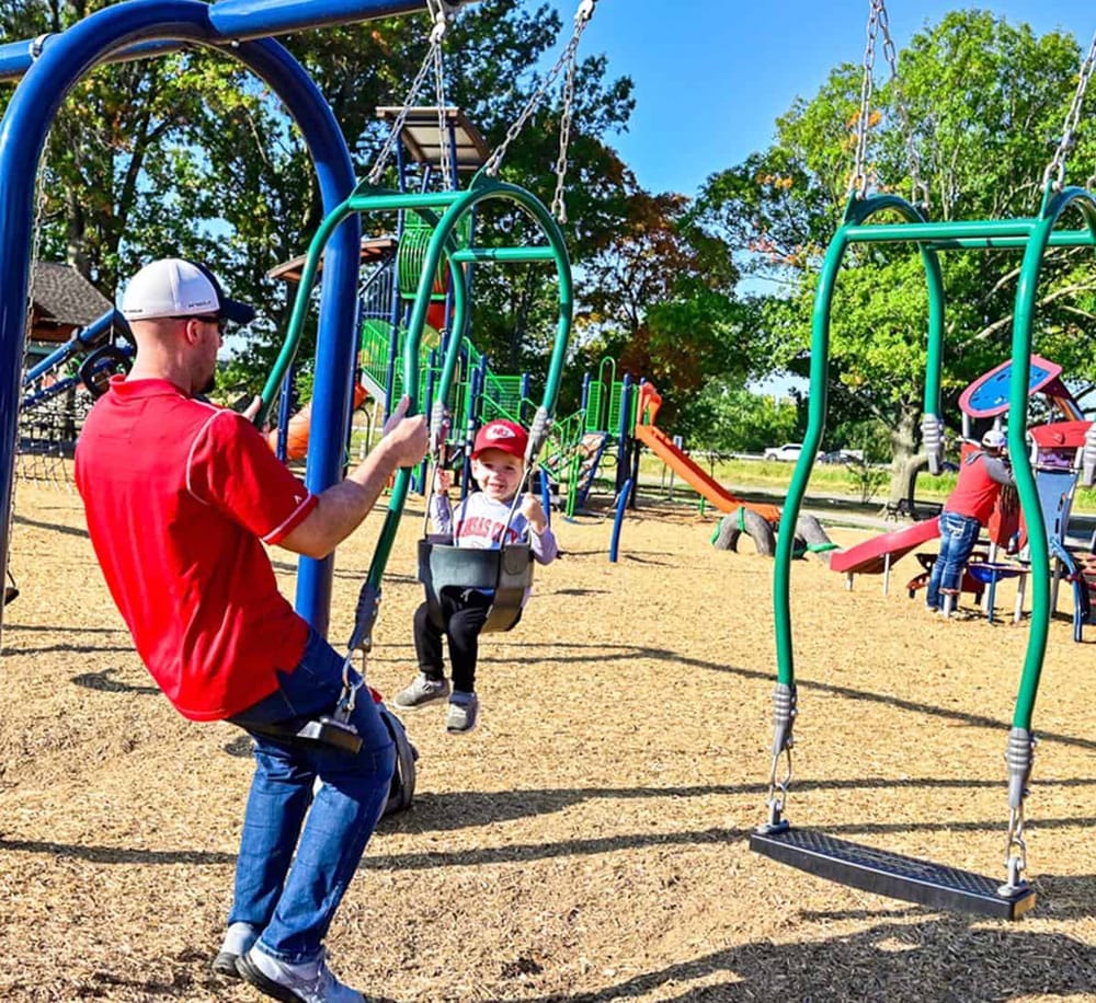 Colorful playground with swings and slides in a park, perfect for family fun and outdoor recreation.