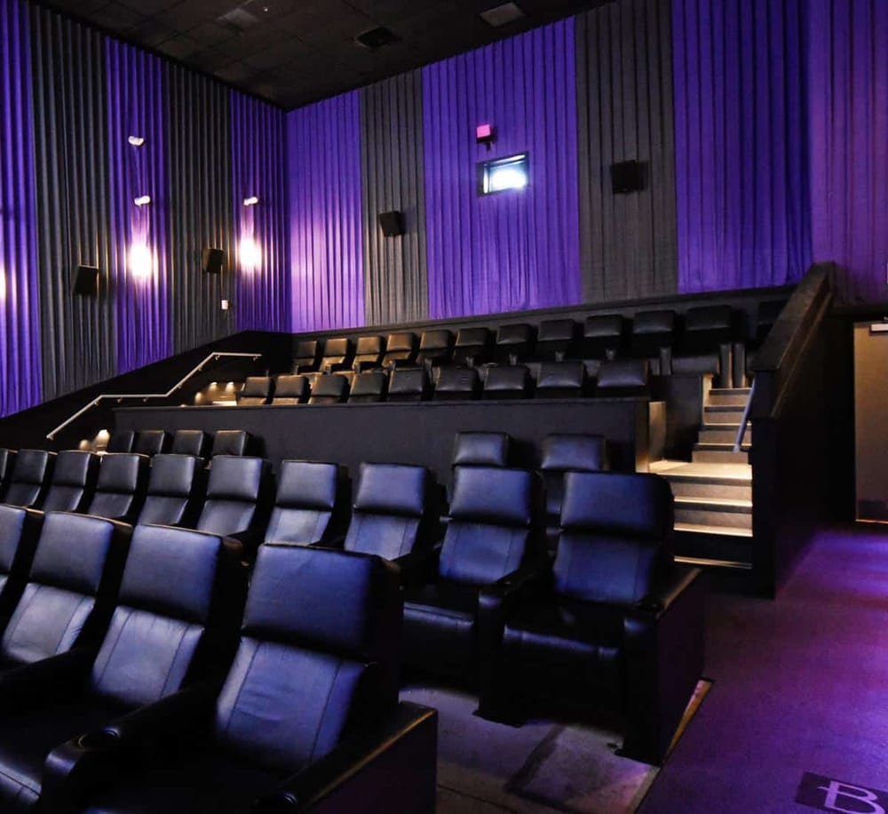 Comfortable movie theater seats with purple lighting, perfect for an immersive cinematic experience.
