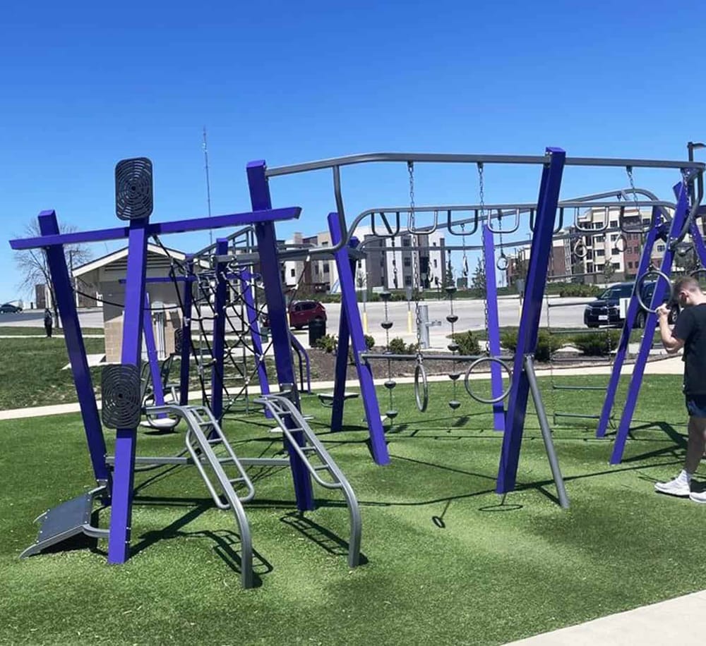 Modern playground equipment with swings and climbing structures at QuestForDirections outdoor area.