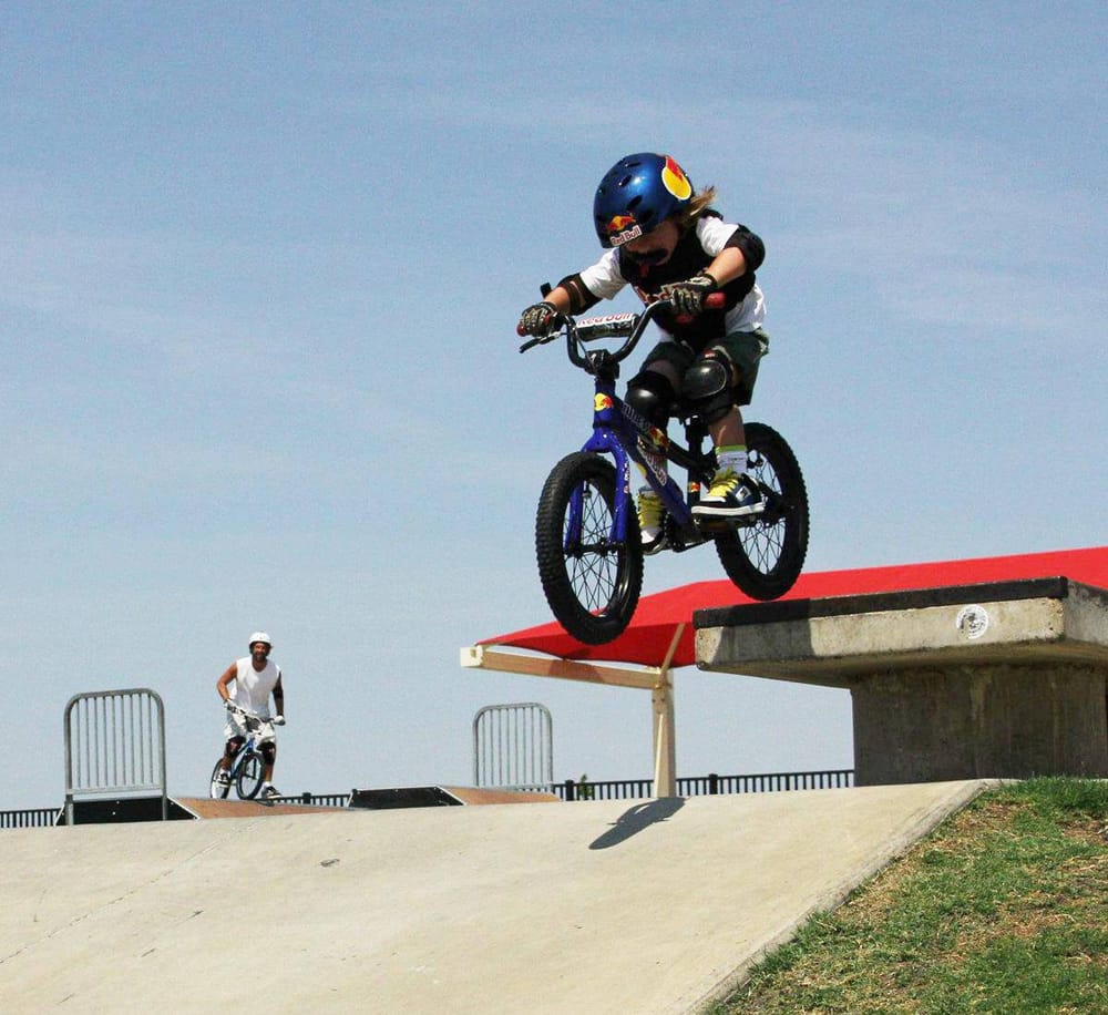 Vivid image of kids enjoying BMX biking at an outdoor skatepark, emphasizing adventure and outdoor activities.