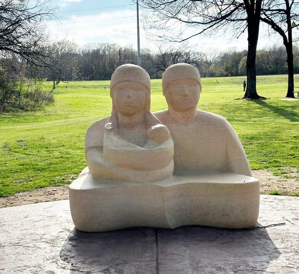 Happy Family Sculpture in a park, showcasing outdoor art, fun family moments, and scenic green landscape.