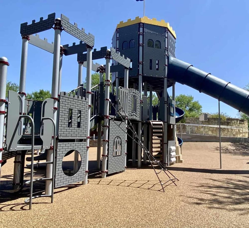 Colorful playground structure with slides and climbing features at QuestForDirections park.