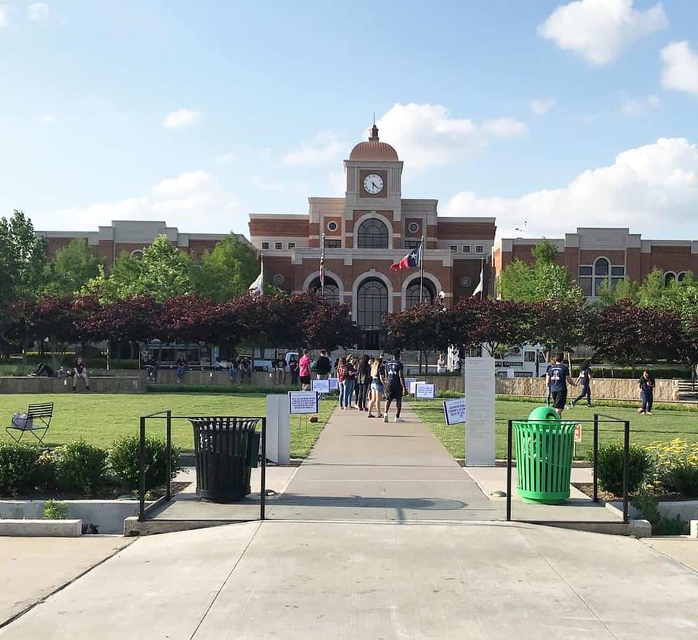 1. Historic courthouse with clock tower and Texas flags, community gathering on sunny day.