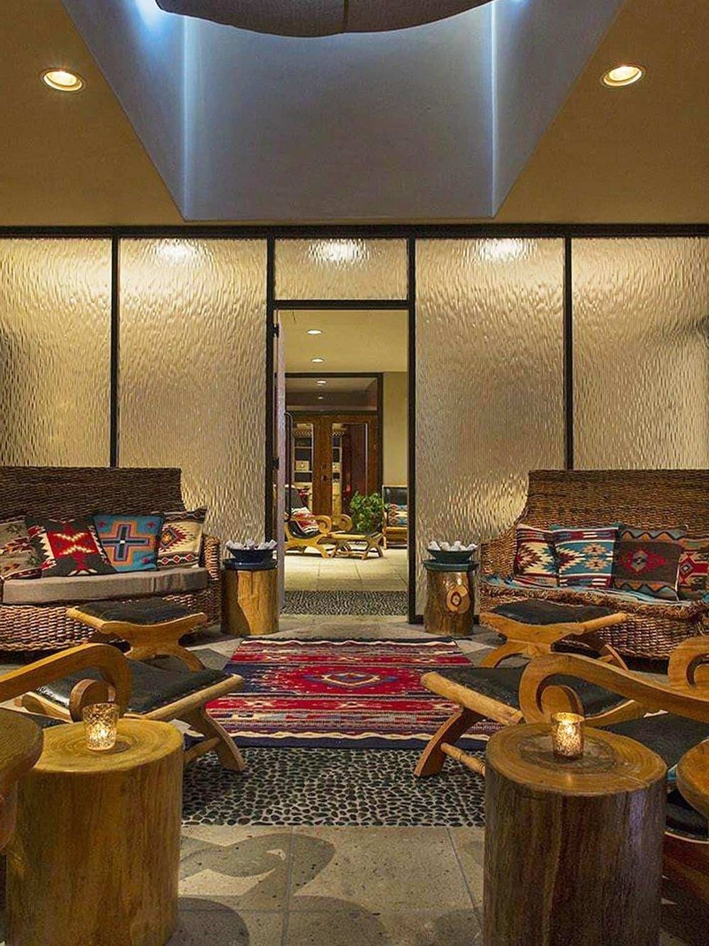 Cozy hotel lounge with tribal-themed decor, warm lighting, and comfortable seating areas for guests.