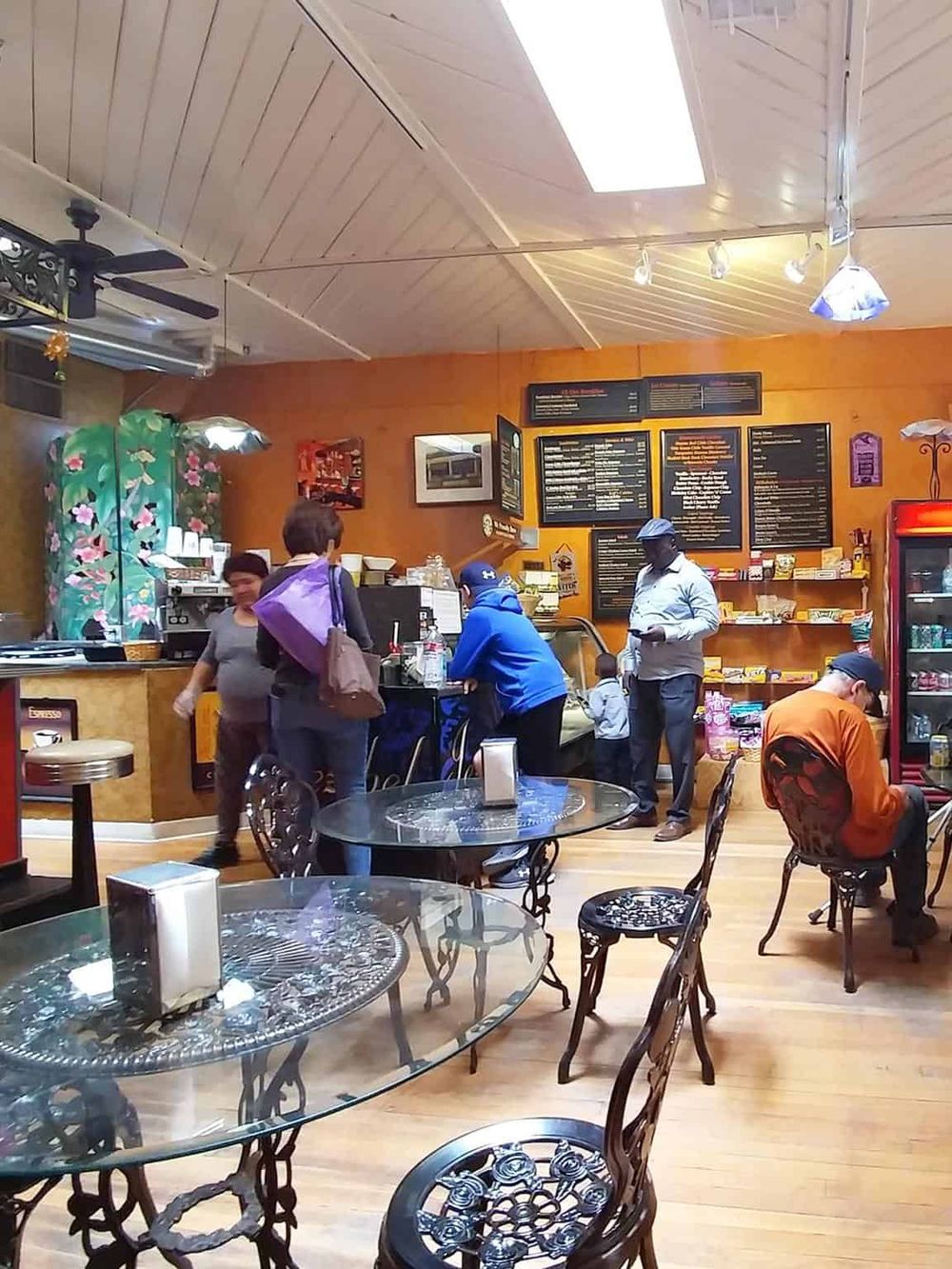 Cozy coffee shop interior with customers, wooden decor, and menu boards. Perfect for relaxing or working with quality coffee.