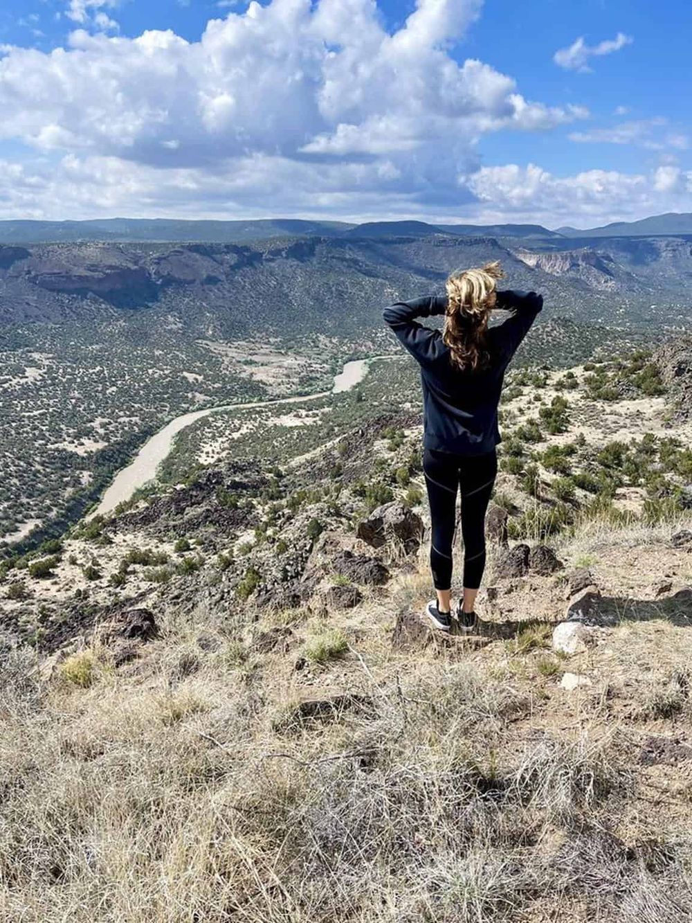 Breathtaking view of a canyon with a woman overlooking the scenic landscape, highlighting adventure and exploration.